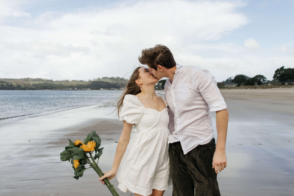 Candid photograph of Chanelle and Calvin embracing right after their proposal at Cooks Beach