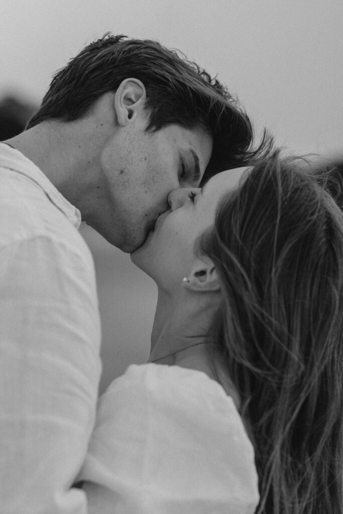 Candid photograph of Chanelle and Calvin embracing right after their proposal at Cooks Beach