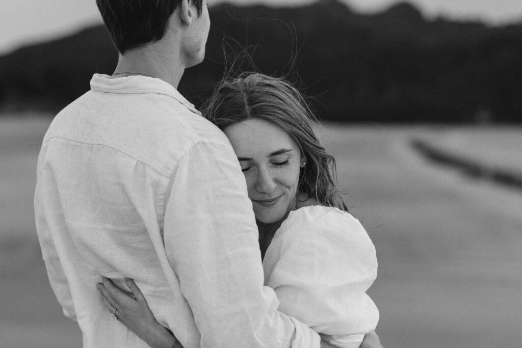 Candid photograph of Chanelle and Calvin embracing right after their proposal at Cooks Beach
