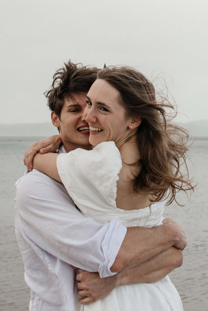 Cooks Beach photographer capturing natural, candid laughter between the couple during their engagement session.