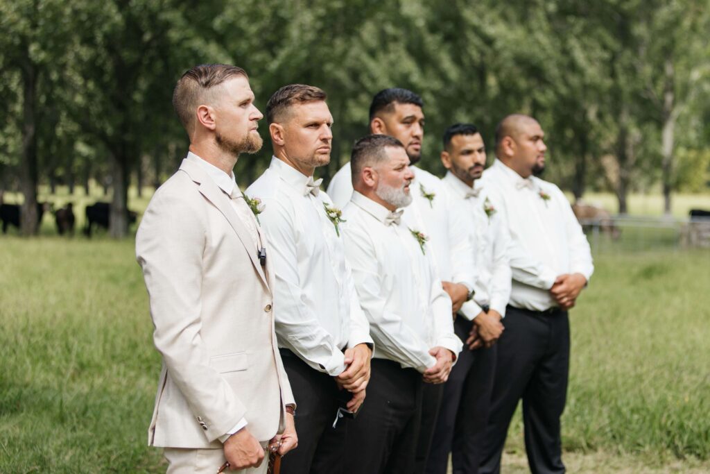 Outdoor Whangamata wedding ceremony with farm backdrop and rolling Coromandel hills.