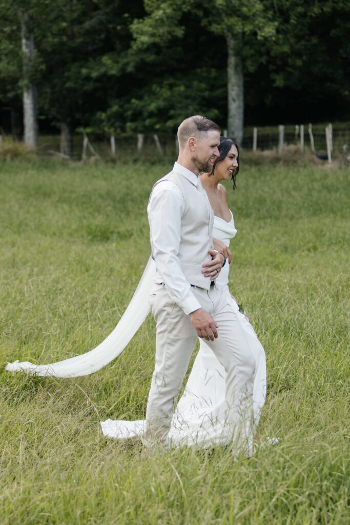 Romantic candid photo of bride and groom at Whangamata Farm Weddings, celebrating their Whangamata wedding.
