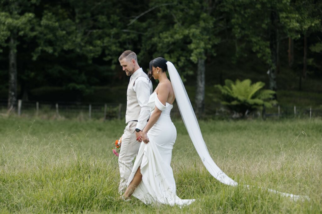 Romantic candid photo of bride and groom at Whangamata Farm Weddings, celebrating their Whangamata wedding.