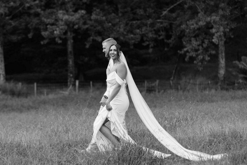 Romantic candid photo of bride and groom at Whangamata Farm Weddings, celebrating their Whangamata wedding.