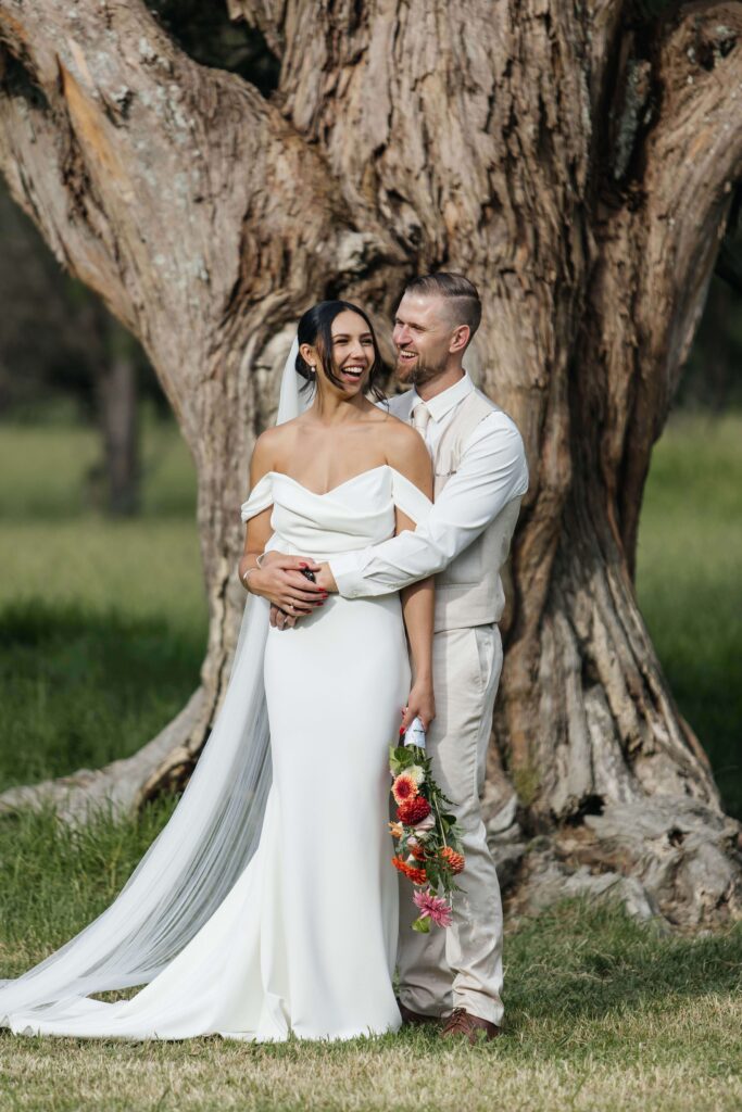 Romantic candid photo of bride and groom at Whangamata Farm Weddings, celebrating their Whangamata wedding.