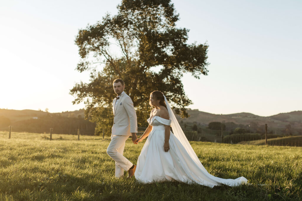 Golden hour portraits of bride and groom in paddocks at The Red Barn Karapiro