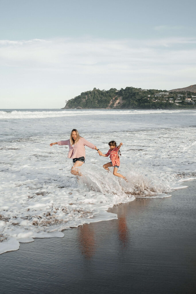 Mother and child walking along Hot Water Beach shoreline