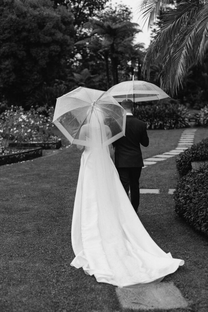 Bride and Groom walking through Puketutu Island Estate gardens