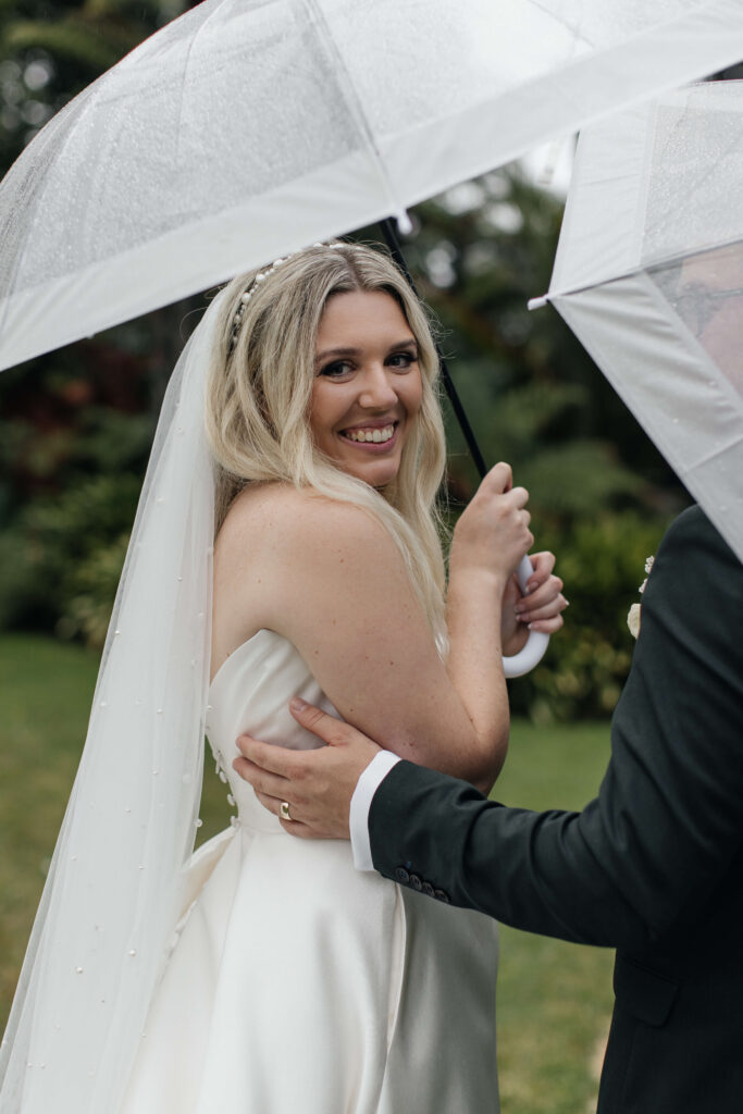 Bride and groom kissing under umbrella at Puketutu Island Estate Auckland