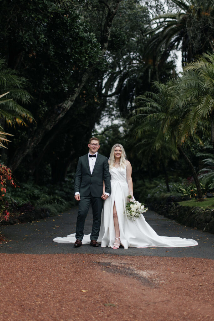 Bride and Groom walking through Puketutu Island Estate gardens