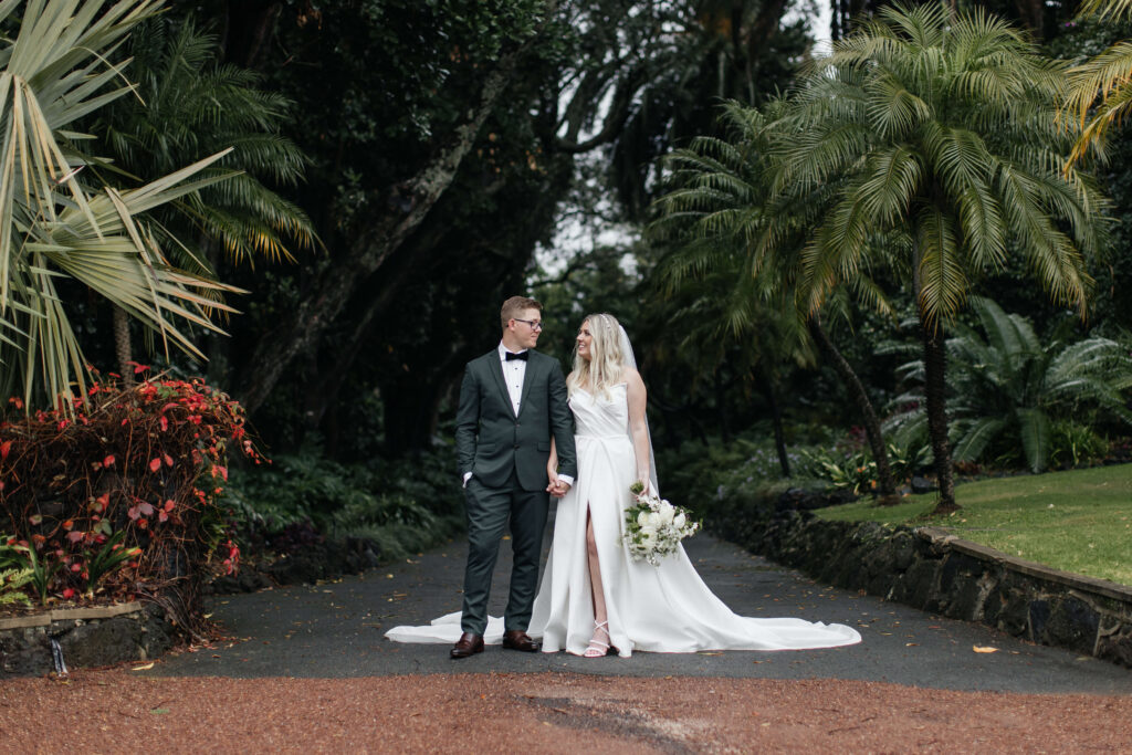 Bride and Groom walking through Puketutu Island Estate gardens