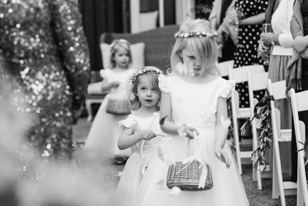 Flower girls walking down the aisle during the wedding ceremony at Mudbrick Lodge on Waiheke Island
