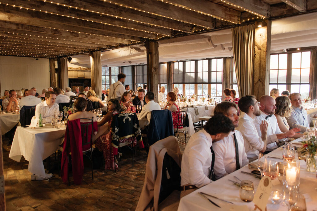 Guests laughing and sharing speeches during wedding reception at Mudbrick – Waiheke Island vineyard wedding