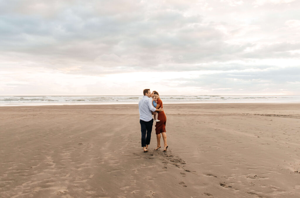 Sunset family session with warm pastel sky at Bethells