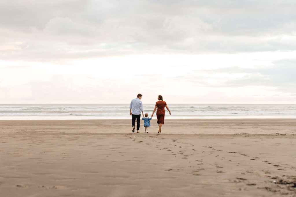 Sunset family session with warm pastel sky at Bethells
