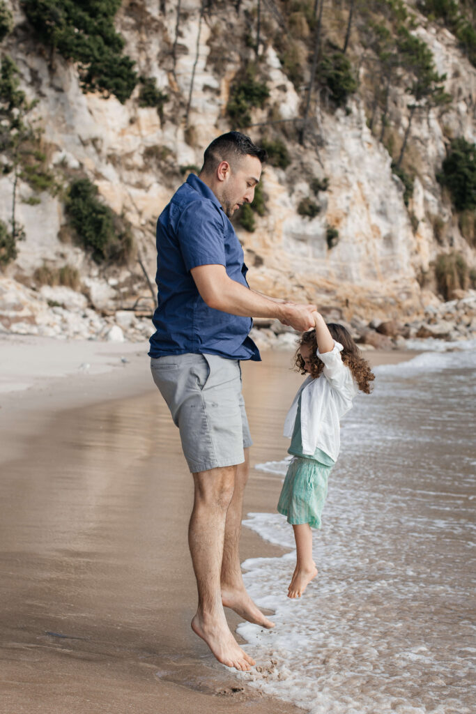 Candid family moment at Hahei Beach with kids laughing and playing