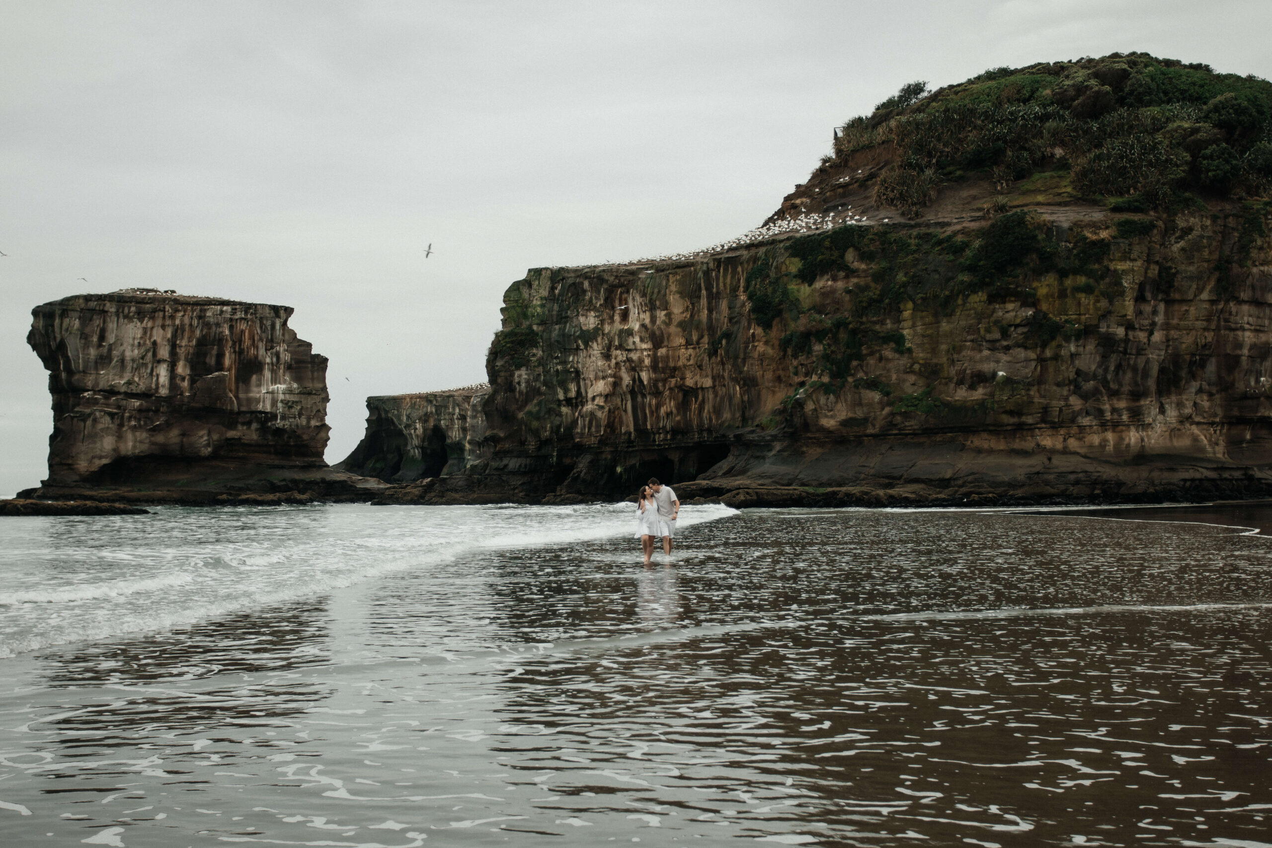 Moody rainy engagement photo shoot at Māori Bay
