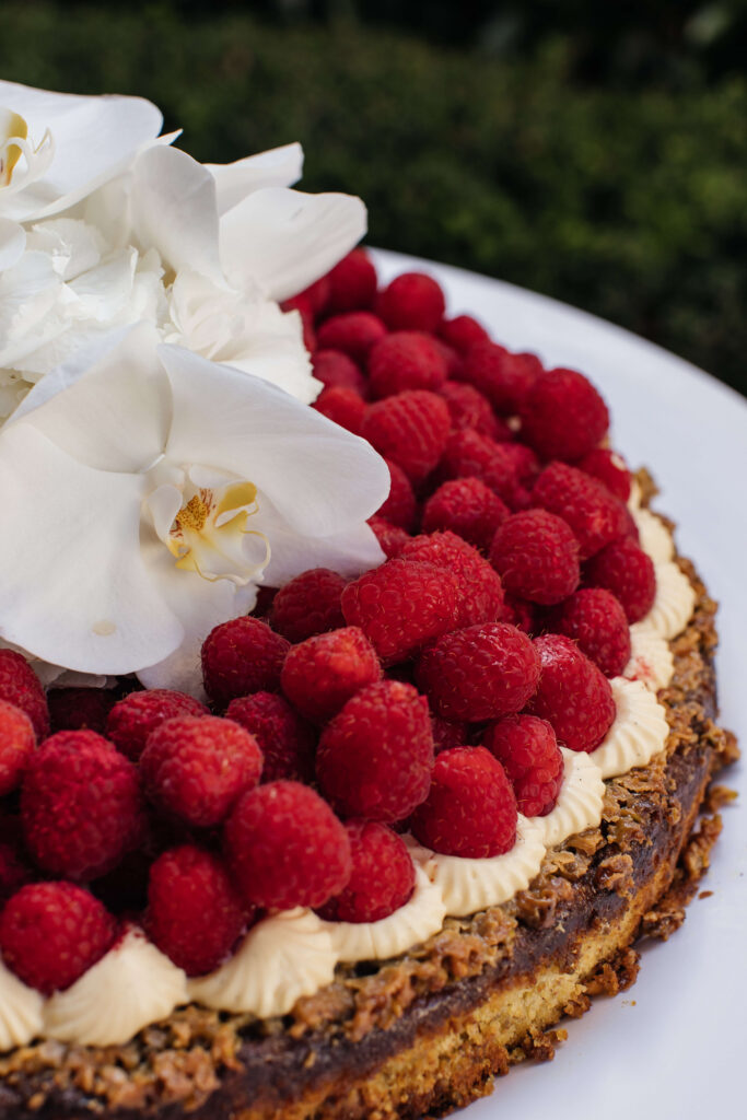 Mediterranean-style wedding cake with fresh raspberries created by Guy Kidd at PAX Venue Auckland wedding.