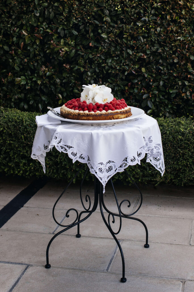 Mediterranean-style wedding cake with fresh raspberries created by Guy Kidd at PAX Venue Auckland wedding.
