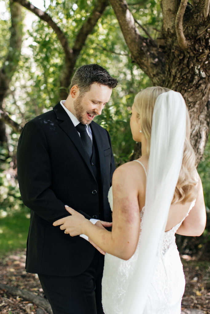 Bride and groom sharing a private first look in the gardens of Abel Estate before their Auckland wedding ceremony.