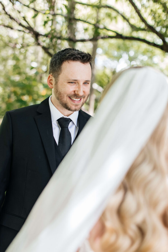 Bride and groom sharing a private first look in the gardens of Abel Estate before their Auckland wedding ceremony.