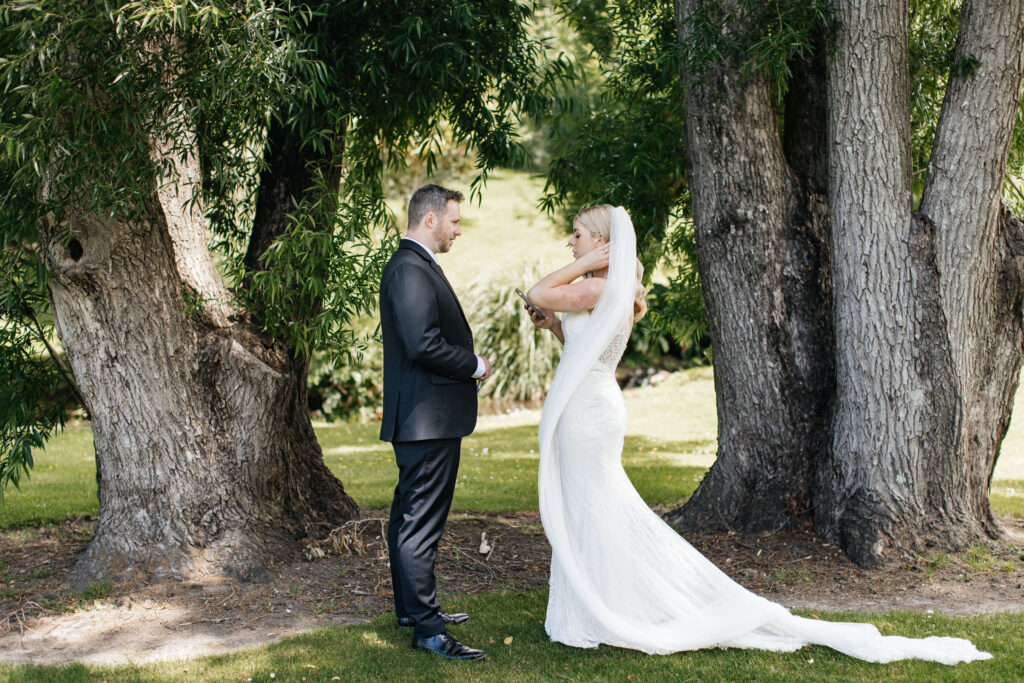 Bride and groom sharing a private first look in the gardens of Abel Estate before their Auckland wedding ceremony.