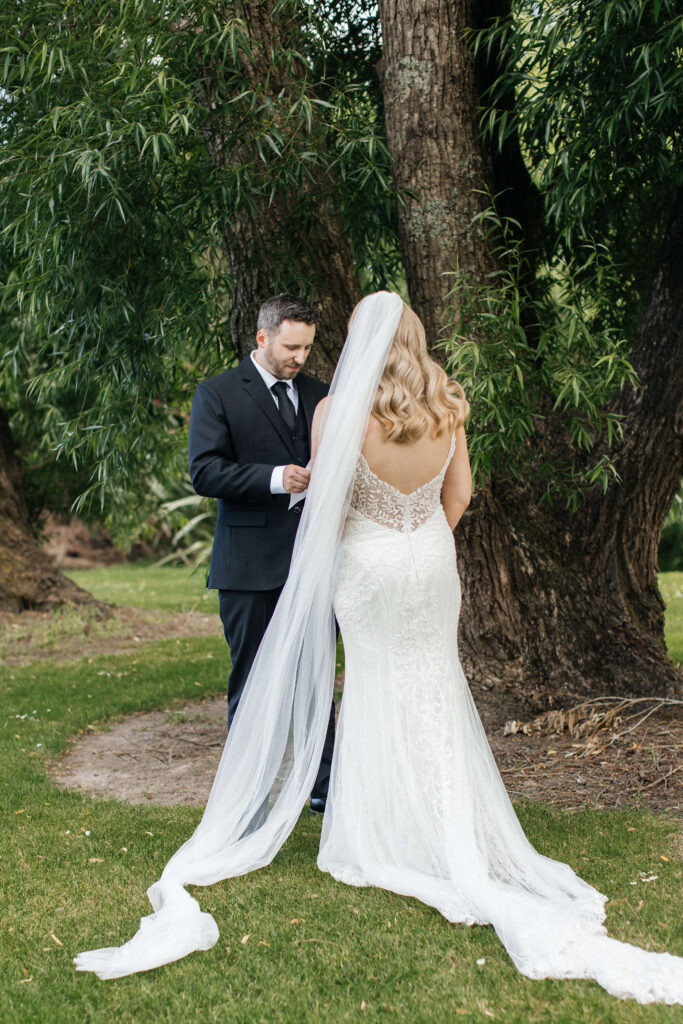 Shay and Howerd sharing private vows in the gardens at Abel Estate, captured candidly by their Auckland wedding photographer.