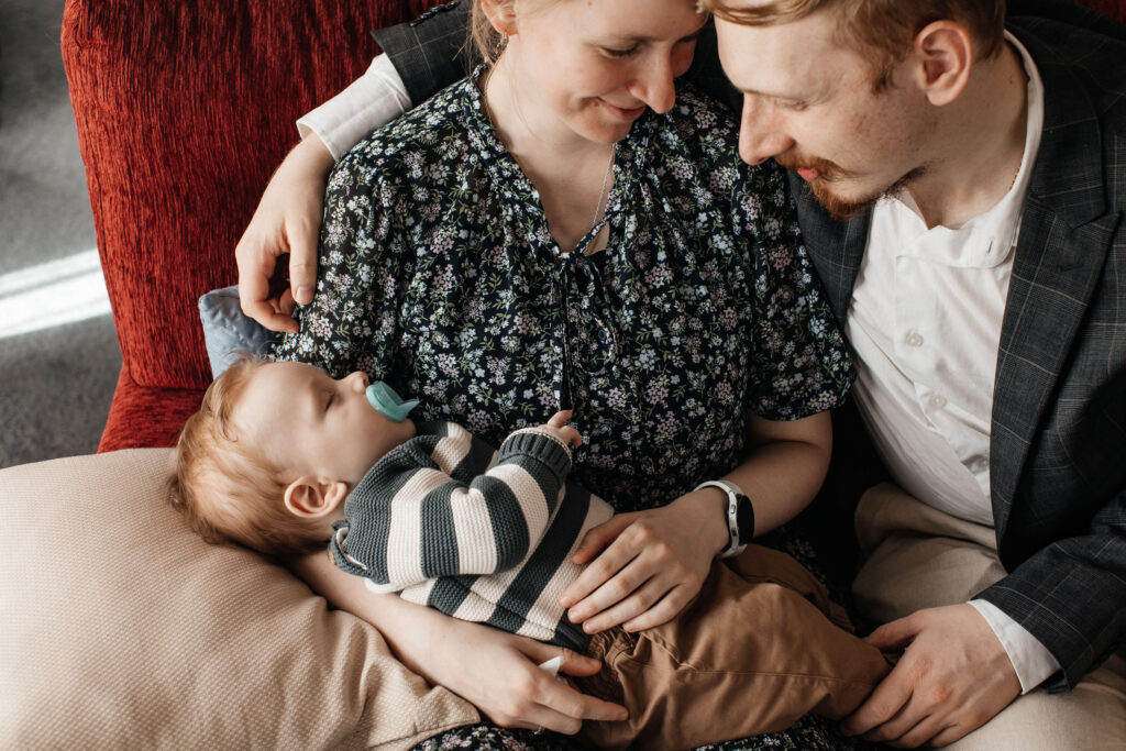 Relaxed family portrait of mum, dad, and son together in their home – a lifestyle family photoshoot capturing everyday moments.