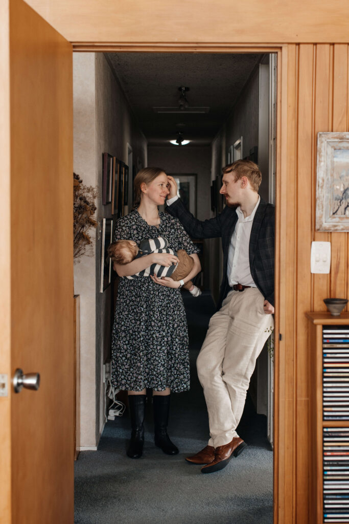 Relaxed family portrait of mum, dad, and son together in their home – a lifestyle family photoshoot capturing everyday moments.