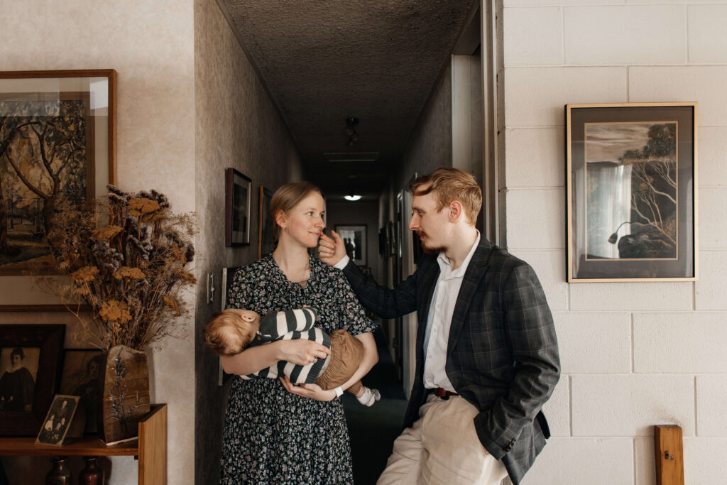 Relaxed family portrait of mum, dad, and son together in their home – a lifestyle family photoshoot capturing everyday moments.