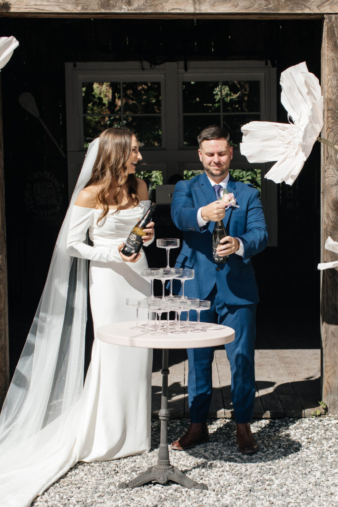 Bride and groom pouring champagne tower at Old Forest School wedding reception.