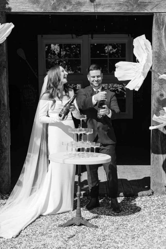 Bride and groom pouring champagne tower at Old Forest School wedding reception.