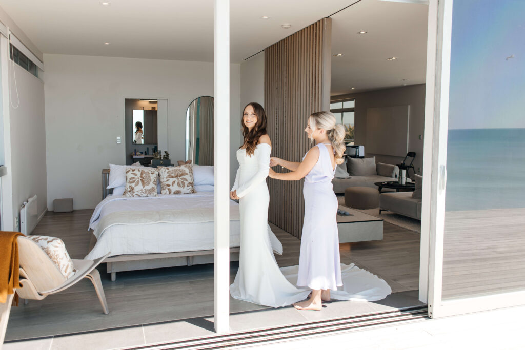 Bride getting ready for her Old Forest School wedding at beachfront accommodation in Pukehina.