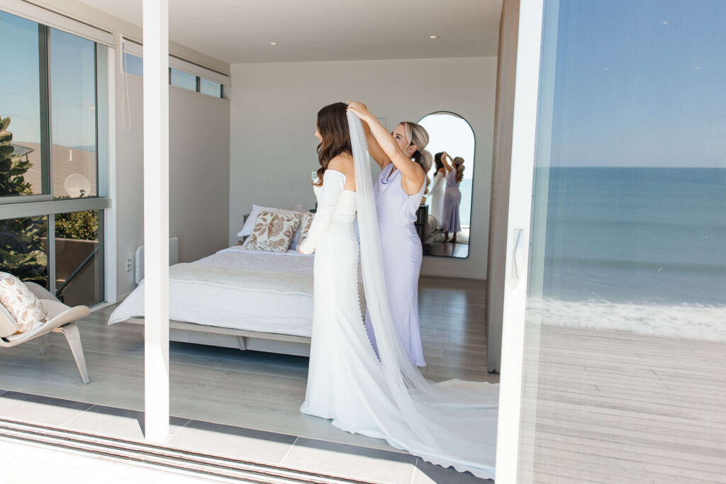 Bride getting ready for her Old Forest School wedding at beachfront accommodation in Pukehina.